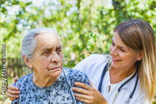 Seniorin mit Ärztin im Garten